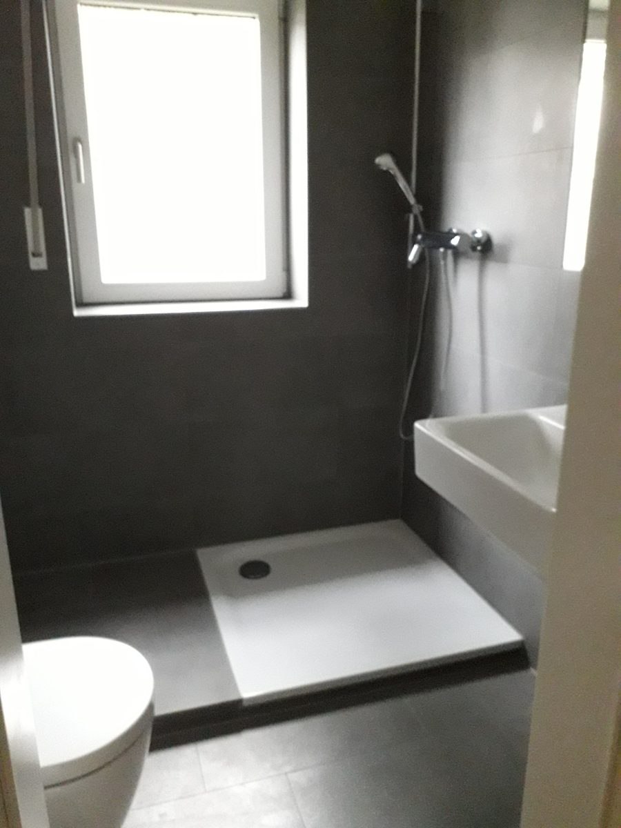 Frisch gereinigtes, neu saniertes Badezimmer mit Dusche und Waschbecken