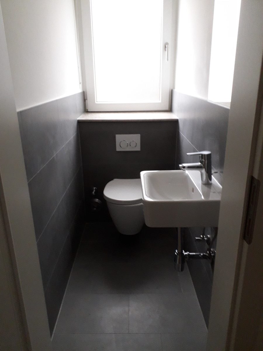 Frisch gereinigtes, neu saniertes Gäste-WC mit Waschbecken