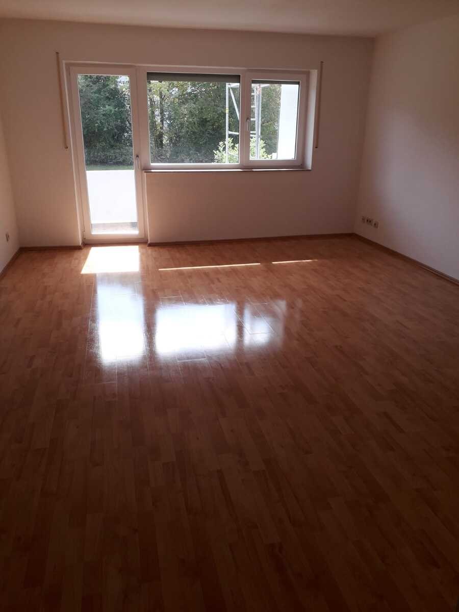 Leeres, frisch gereinigtes Wohnzimmer mit Balkontür nach einer Renovierung
